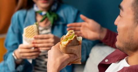A couple is chatting while holding half-eaten wraps in their hands. (Representative Cover Image Source: Freepik)