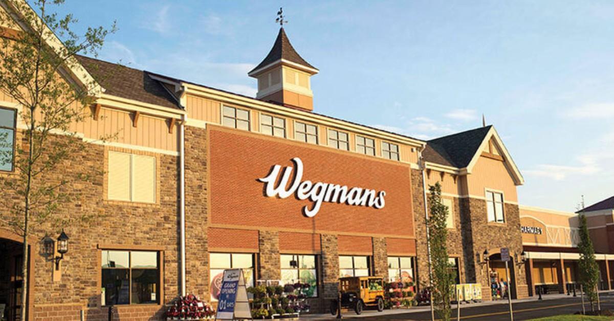 A Wegmans storefront is brightly lit on a sunny day in Alexandria, Virginia