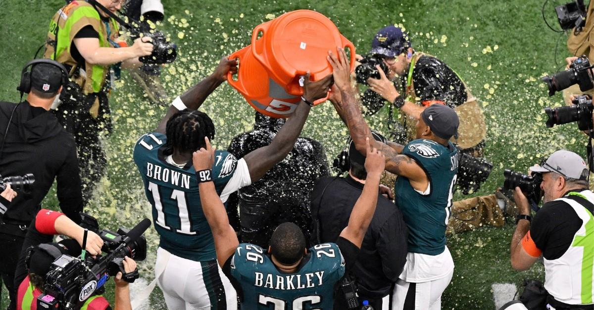 Philadelphia Eagles players dump Gatorade on their coach as reporters take photos and videos after their Super Bowl win