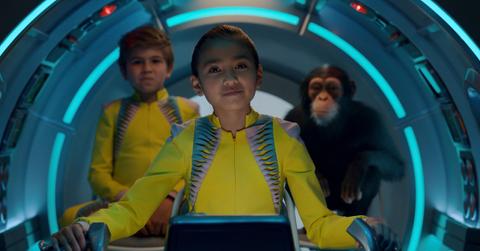 A scene from 'Jane' with the main character in the center of the frame and a boy and chimpanzee at her side