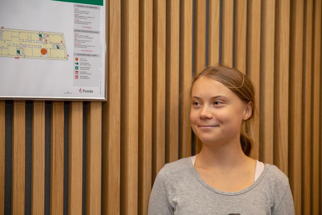 Greta Thunberg smiling while in court.