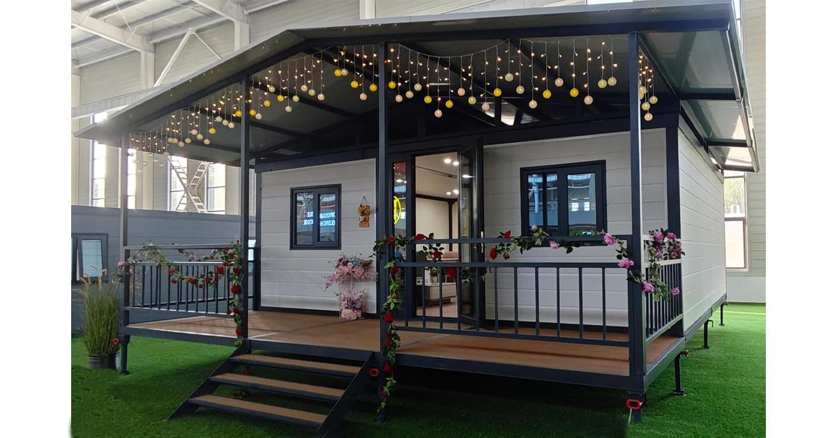 tiny house with white siding and black trim with a balcony and stairs.