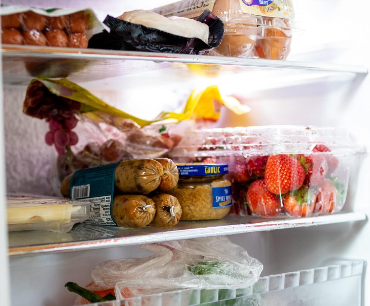 Sausage, minced garlic, and strawberries in a refrigerator