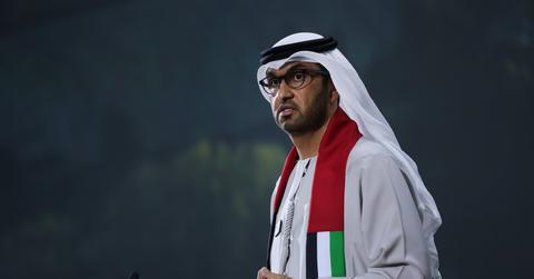 COP28 president Sultan Al Jaber stands at a podium with a microphone speaking to a crowd at the COP28 conference in Dubai.