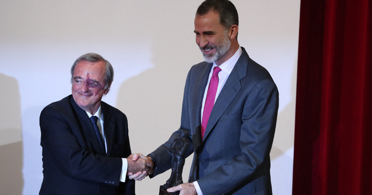 Mariano Barbacid shakes hands with another man as he receives an award