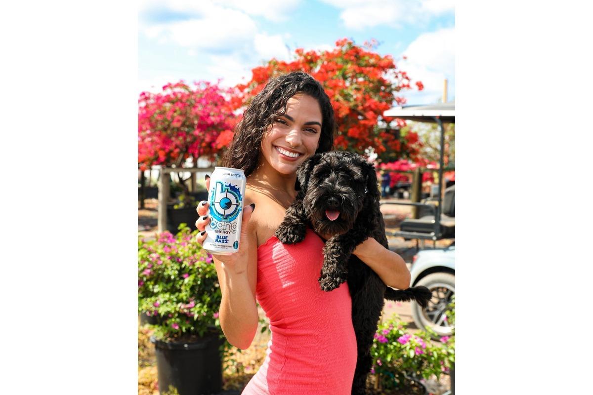 Woman holding Bang Energy drink and a cute dog 