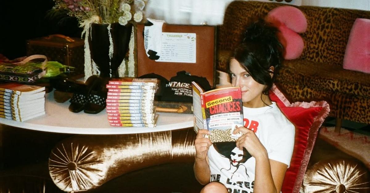 Macy Eleni posing with her book, 'Second Chances: The Ultimate Guide to Thrifting'