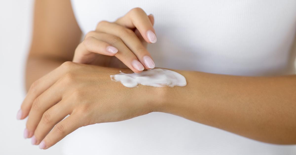 Woman applying sunscreen to her arm. 