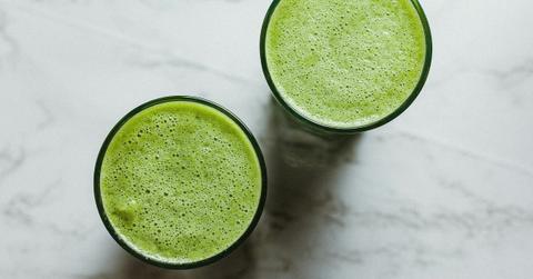 An overhead shot of two glasses of green vegetable juice