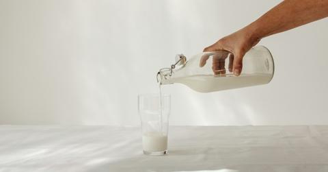man pouring milk into cup