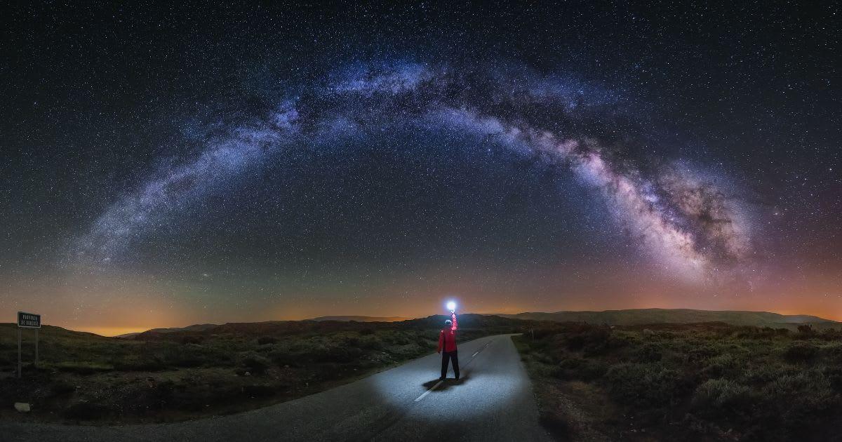 A man on a road watches the Milky Way and lights the road with a flash. (Representative Cover Image Source: Getty Images | Carlos Fernandez)