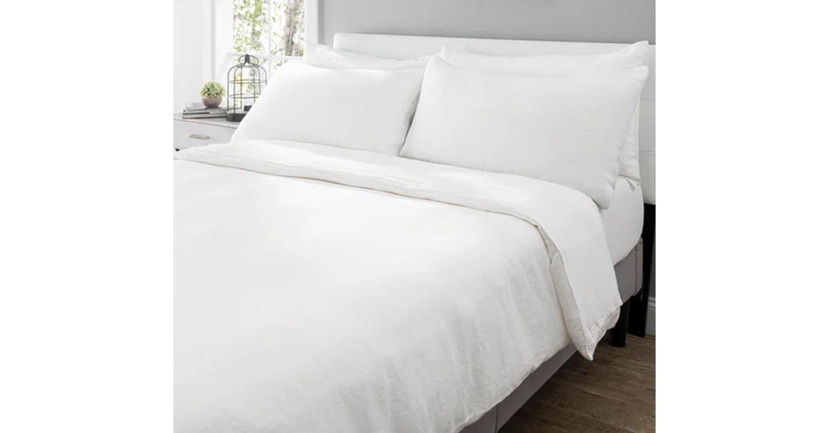 A bed made with white sheets.