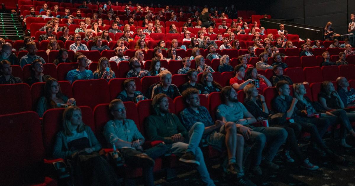 People sit in a movie theatre watching a show