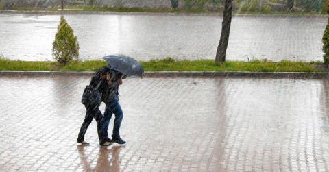 A couple walk together with an umbrella through the rain