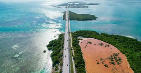 Representational image of a road in the middle of waterbodies (Cover Image Source: Unsplash | Photo by Zoshua Colah)