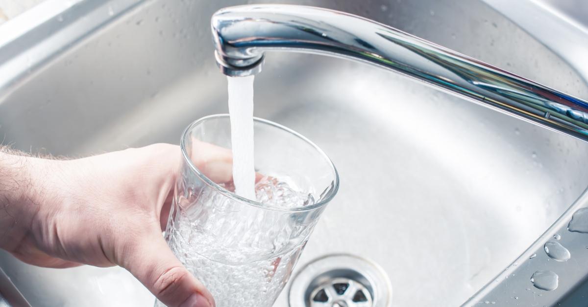 A person filling up a glass with tap water. 