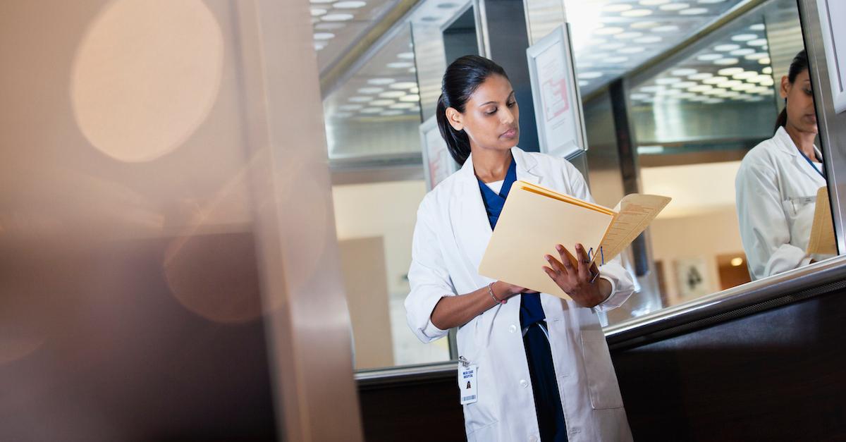 A doctor looks over her patient's file.