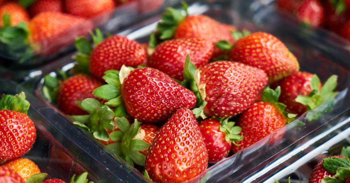 A bushel of strawberries sits on a shelf