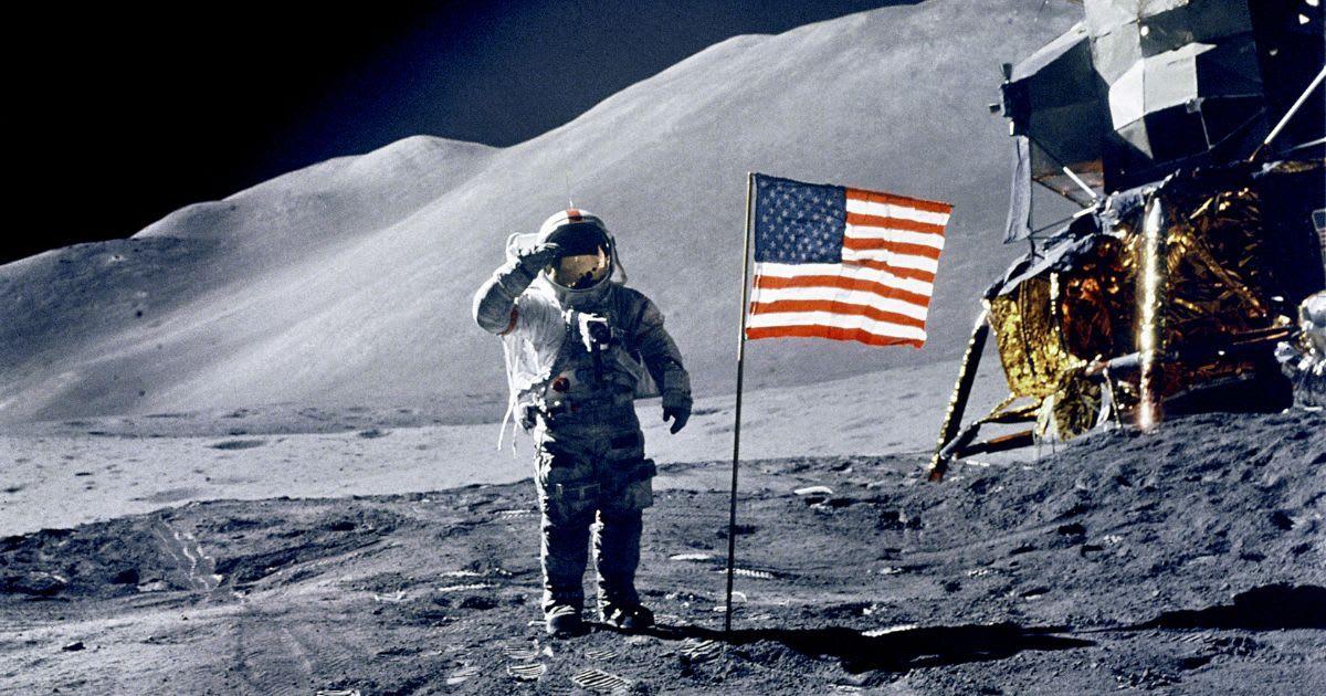 An astronaut on the moon standing next to an American flag. (Representative Cover Image Source: Getty Images | Michael Dunning)