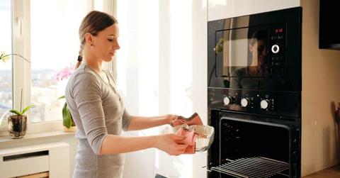 A woman is placing food in the microwave to heat up. (Representative Cover Image Source: Freepik | Arthur Hidden)