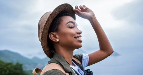 A woman wearing a hat while hiking.