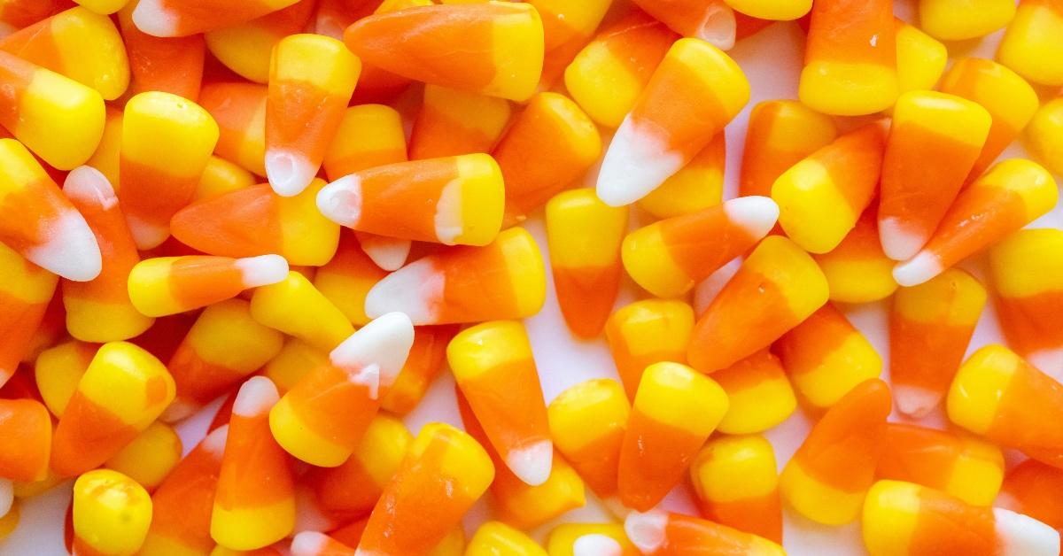 Close-up photograph of candy corn on a white table. 