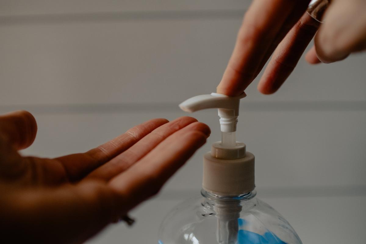 person dispensing soap onto hands