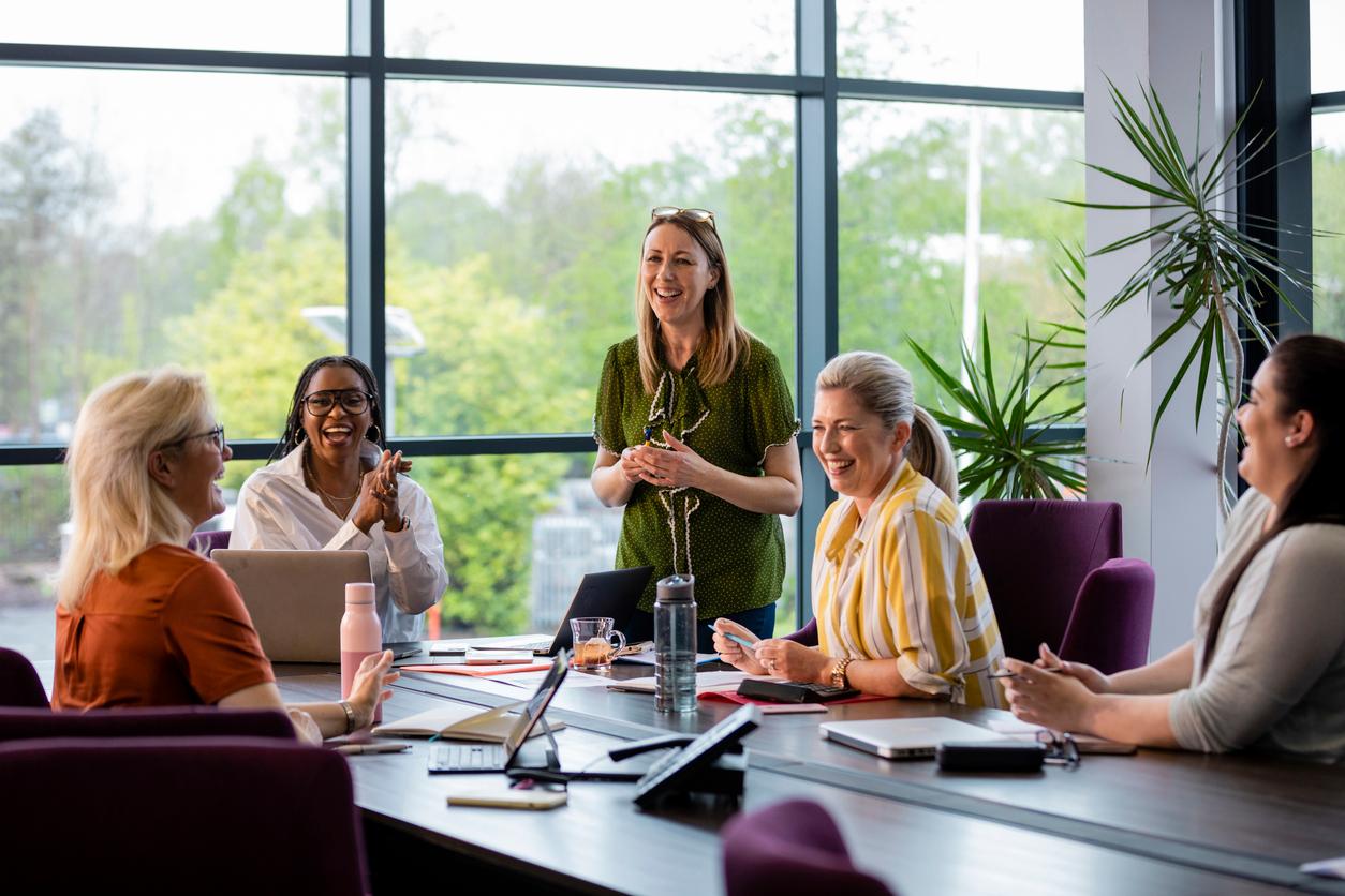 A project manager, symbolically wearing green, discusses sustainable corporate practices in a meeting.