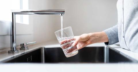 A person is fetching tap water in a glass. (Representative Cover Image Source: Getty Images | Daniel de la Hoz)
