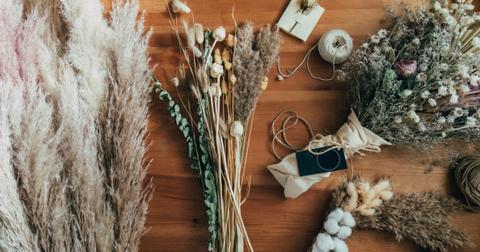 Photo of overhead view of dried flowers and plants on a wood table