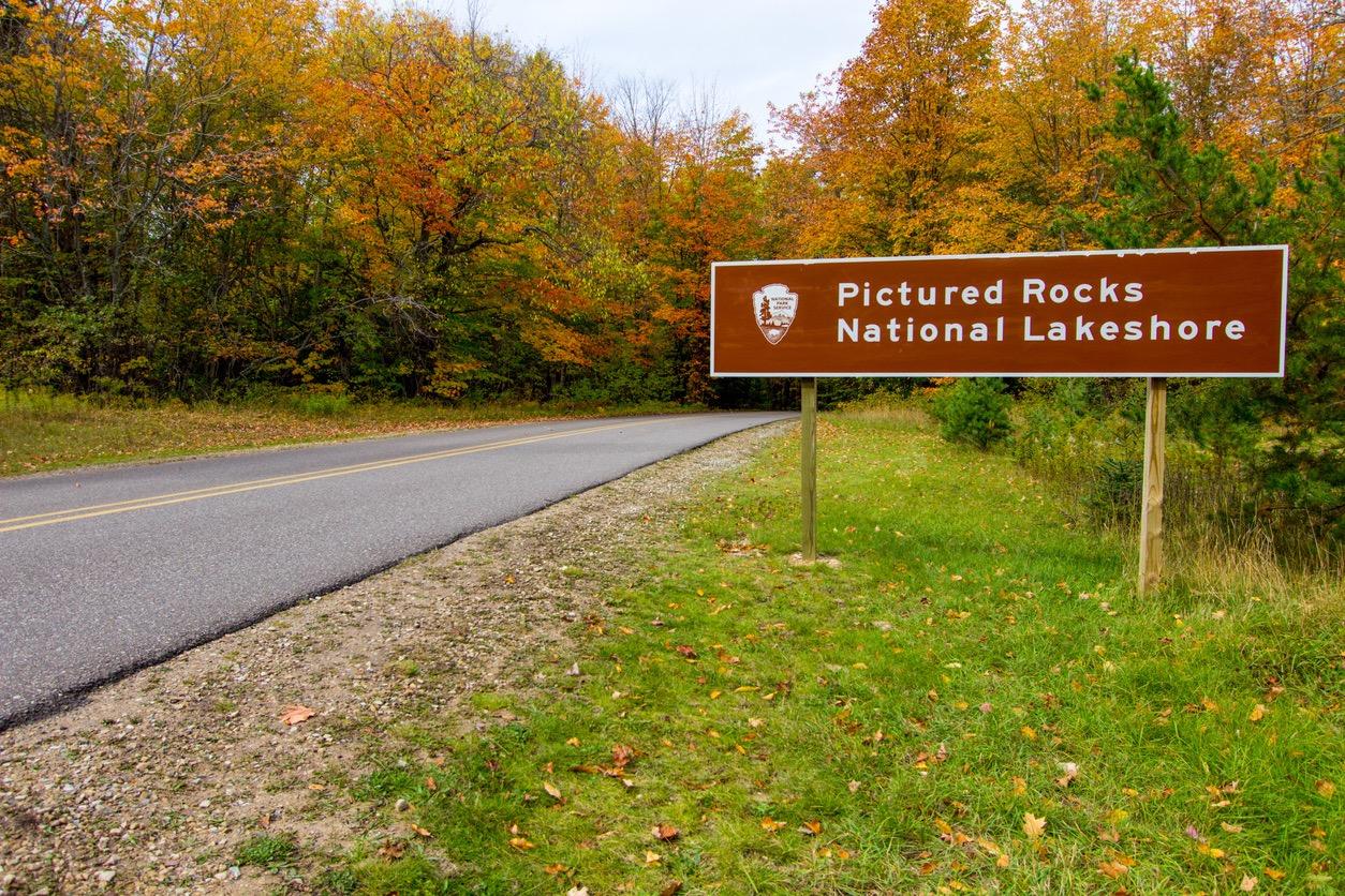 Pictured Rocks National Lakeshore sign next to a road in Michigan during the fall