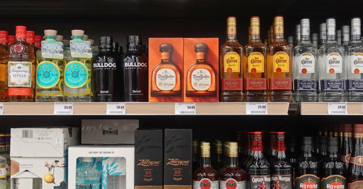 Multiple brands of liquor sit on a shelf in a store, including Don Julio