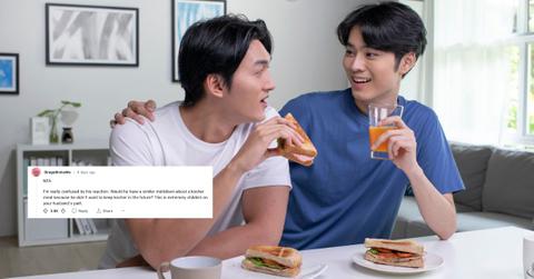 A young Asian couple eating sandwiches together.