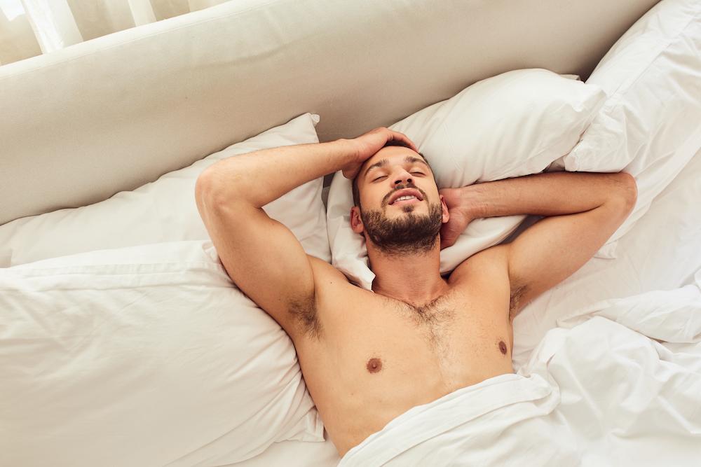 A man smiling and resting in bed