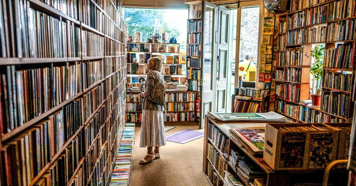 A woman looks at titles in a bookstore 