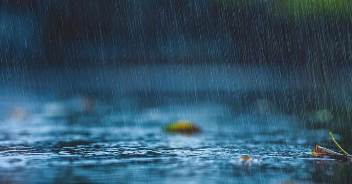 Rain falling down on a sidewalk.