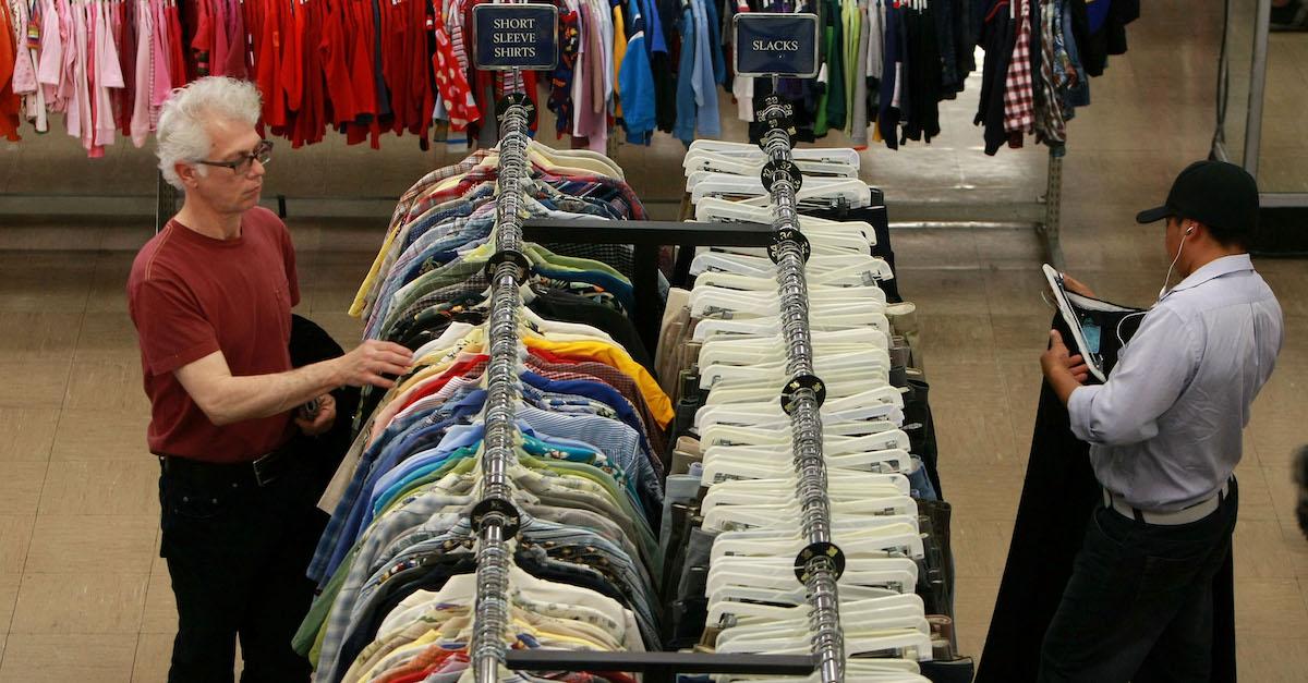 Two men browse racks at a thrift store\