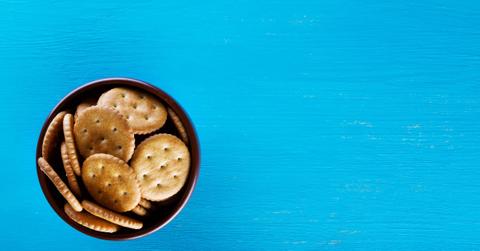 A bowl of Ritz Crackers sits against a blue background