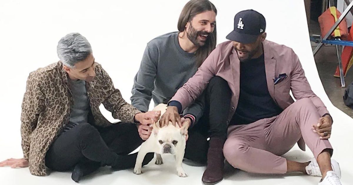 Tan France, Jonathan Van Ness, and Karama Brown all pet a dog.