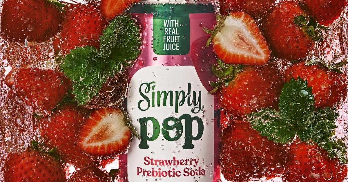 A can of strawberry SImply Pop is surrounded by strawberries in a bubbly liquid