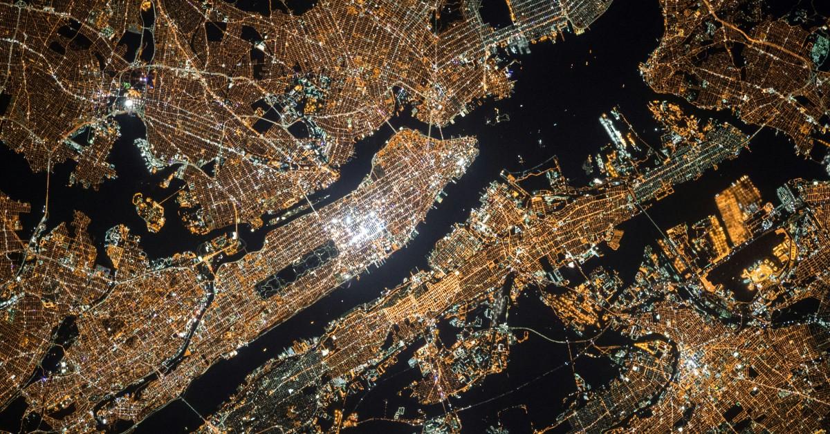 An overhead view of Manhattan, New York City, which shows the city lit up at night