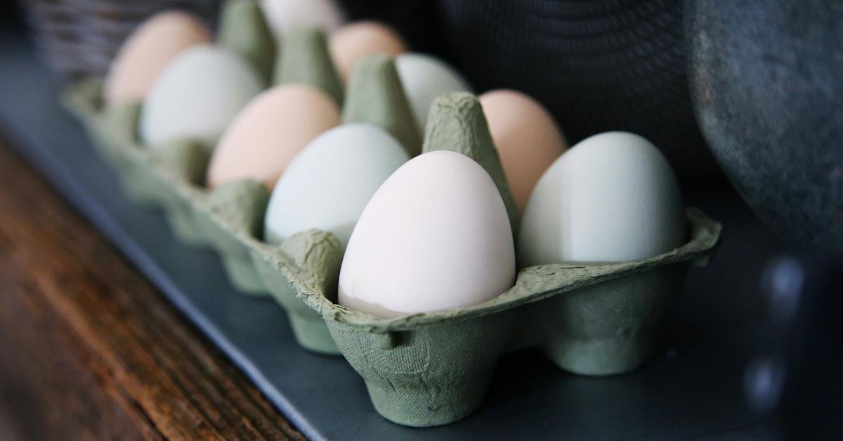 A green carton of white eggs. 