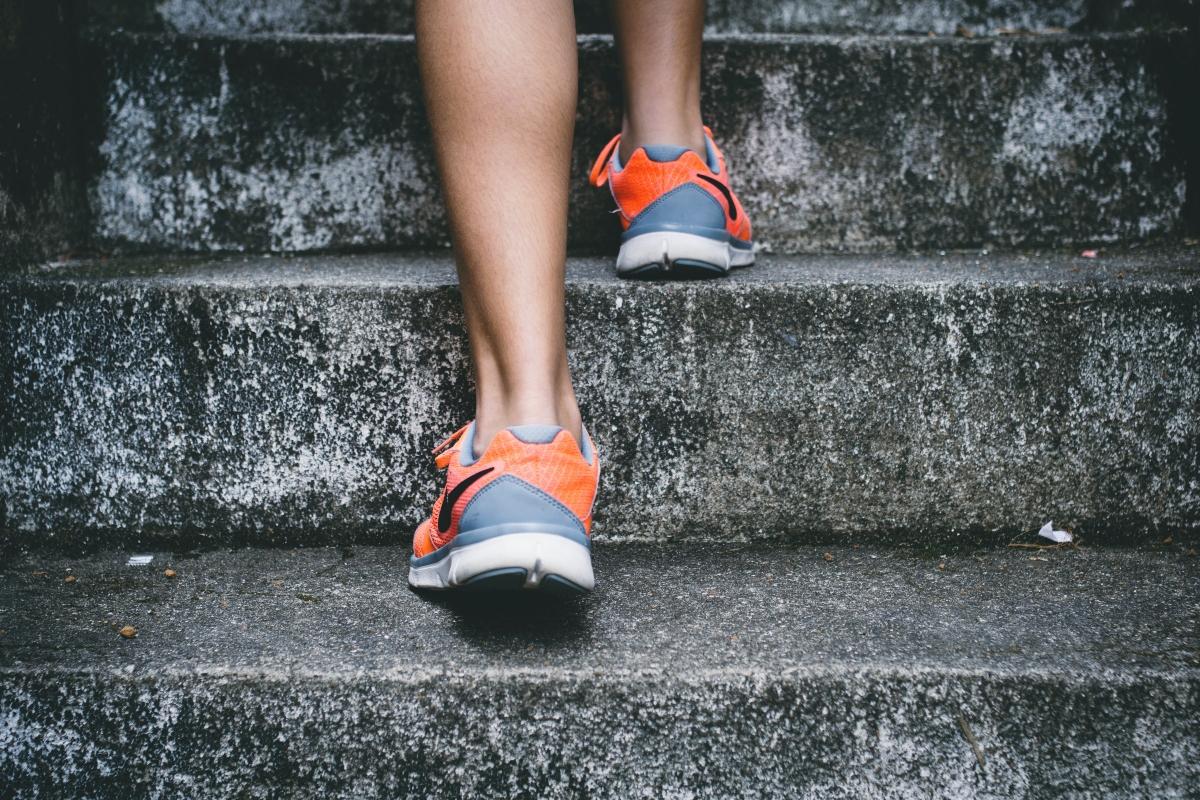 Close-up of feet in athletic shoes on stairs.