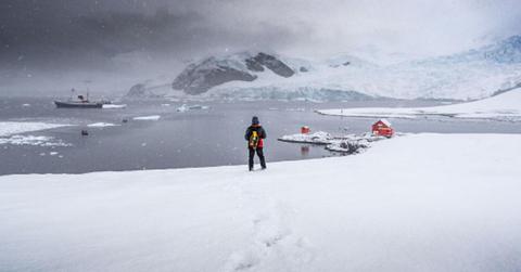 A man looking at the Antarctic landscape. (Representative Cover Image Source: Getty Images | Ruben Earth)