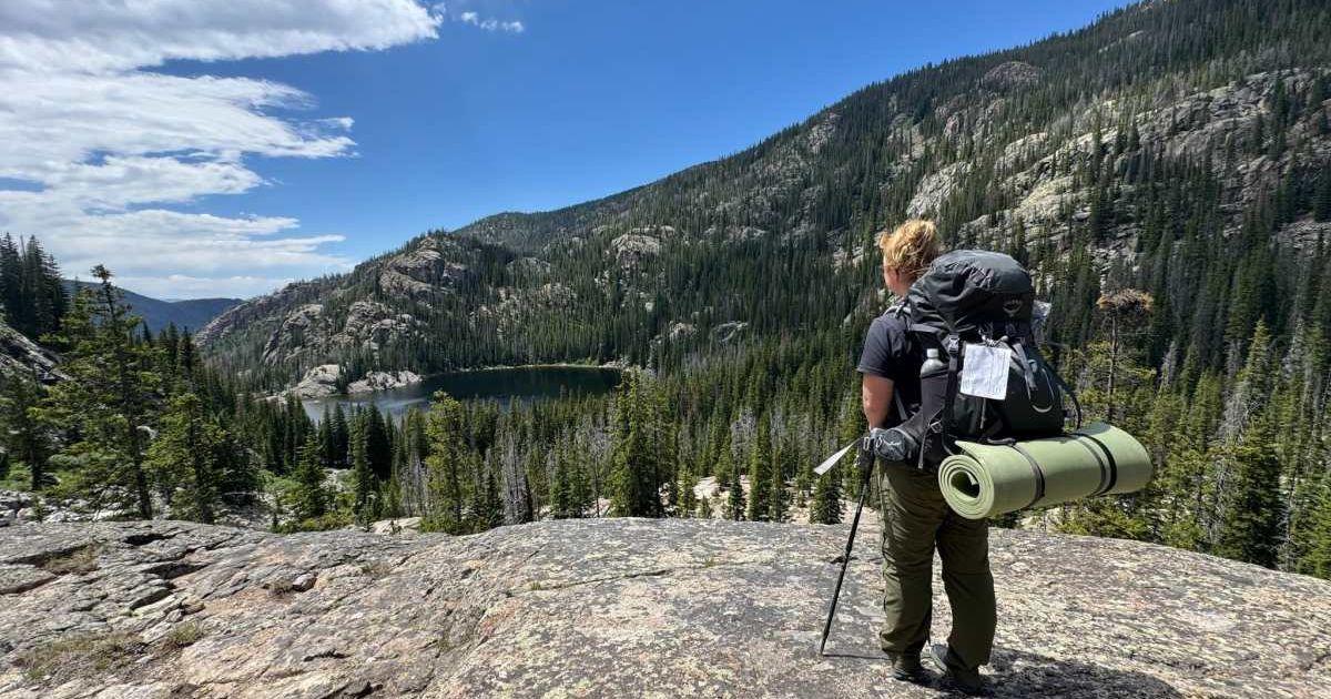 A visitor standing on a sunlit cliff of Rocky Mountains National Park. (Cover Image Source: Facebook | Rocky Mountains National Park/NPS)