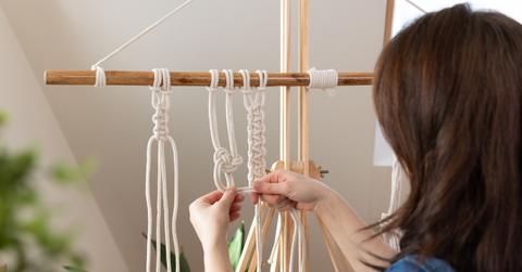 Person working on a macrame project.
