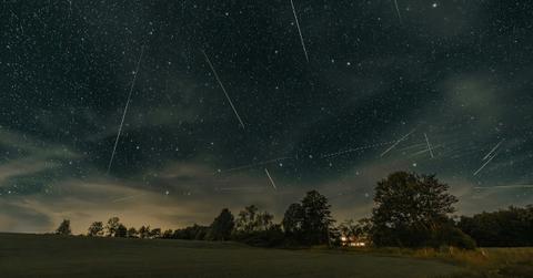 Meteors light up the night sky over a house