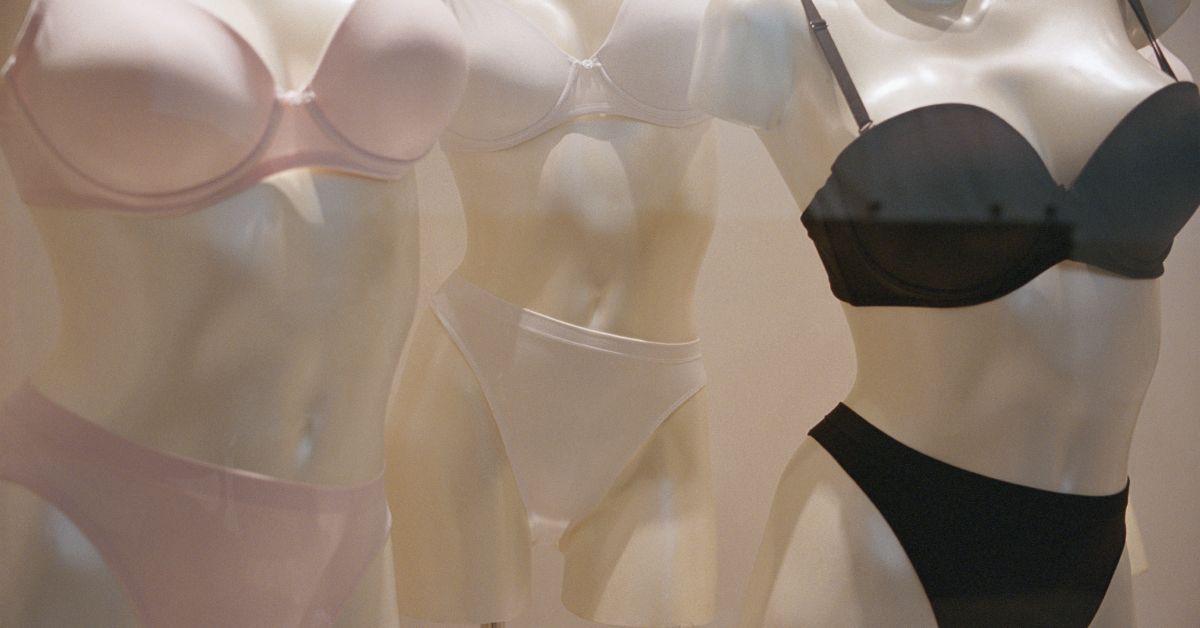 Three mannequins wearing pink, black, and white underwear.