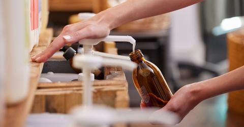 A person refilling a bottle with liquid soap.