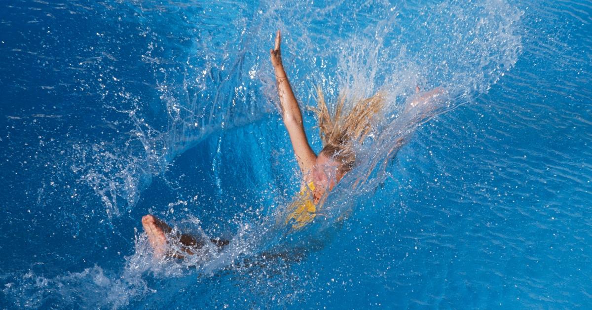 Person leaping into a swimming pool.